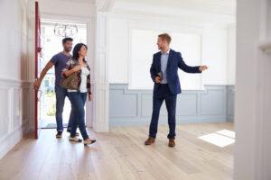 Immobilienmakler zeigt jungem Paar das neue Haus