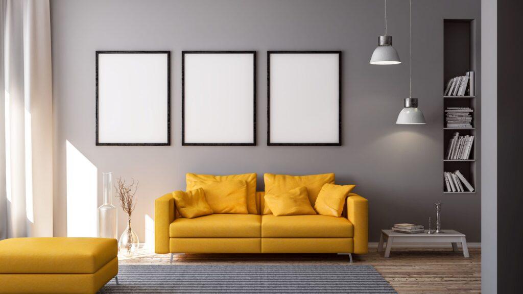 3D Rendering von gelber Couch oder Sofa und leeren Bilderrahmen vor grauer Wand in Raum oder Wohnzimmer einer Wohnung mit modernen Möbeln in minimalistischen Interieur