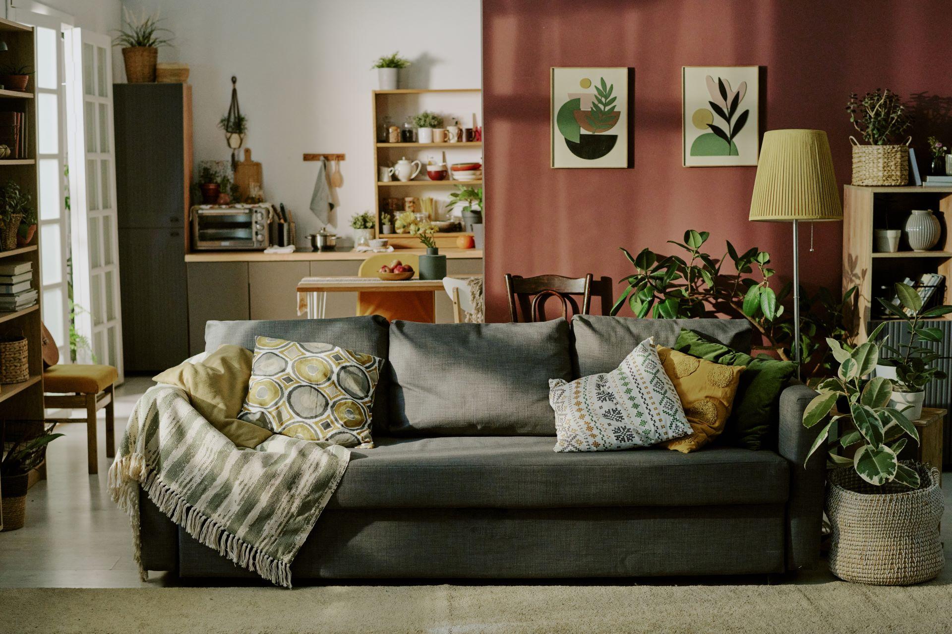 Wohnzimmer mit vielen Pflanzen und gemütlicher Textildecke