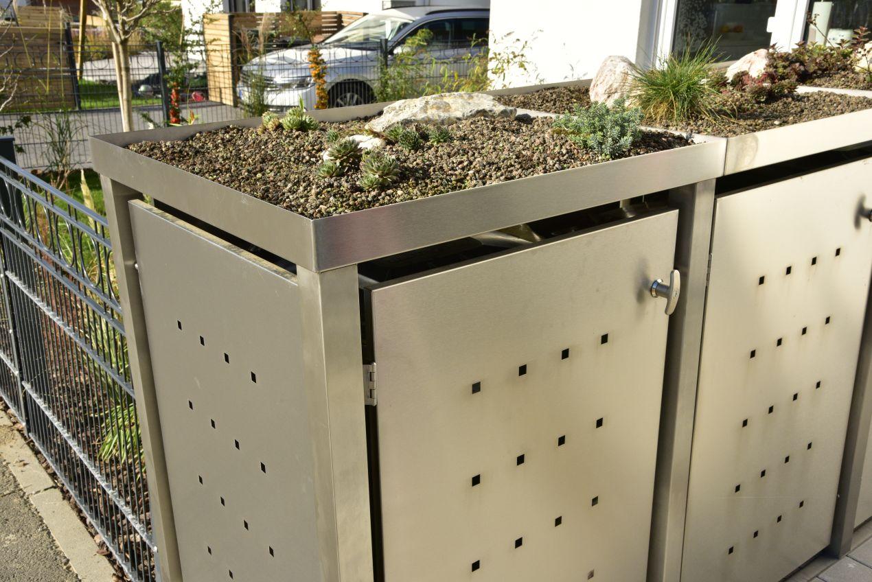 Mülleinhausung aus Edelstahl mit bepflanztem Dach, kombiniert mit modernem Design und versteckter Mülltonne für eine gepflegte Außenanlage